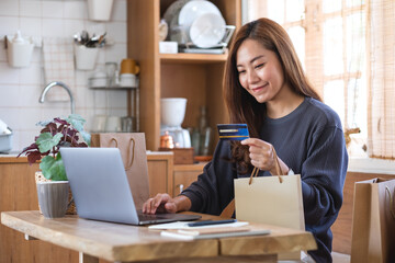 A woman using laptop computer and credit card for online shopping at home