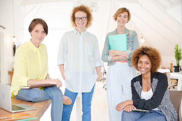Obraz premium Portrait of women smiling in office with laptop on desk