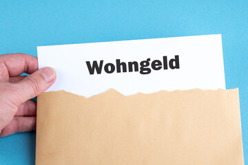 Eine Hand nimmt aus einem Briefumschlag einen Antrag auf Wohngeld heraus