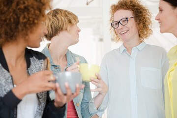 Women with coffe cup smiling in office