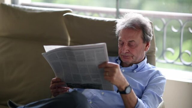 Senior man reading newspaper. older business man reads traditional news