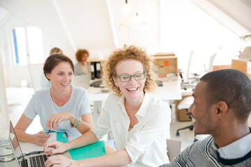 Obraz premium Office workers talking over laptop at desk