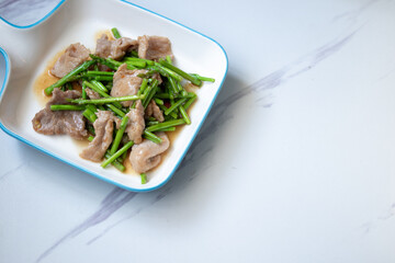 Asparagus sauteed with pork in a white ceramic dish