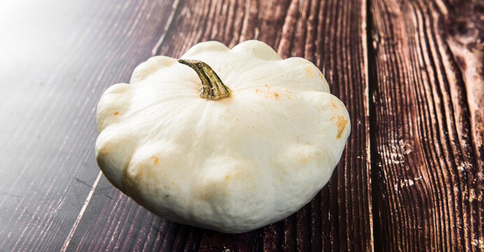 patison pumpkin squashed on dark kitchen table, whole bio raw vegetable brom village gardening