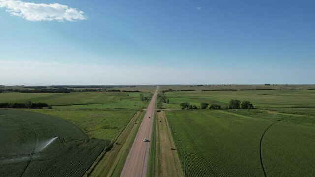 Two lane highway through rural countryside farmland. Aerial 4K drone video in midwest United States.