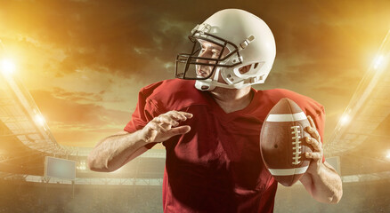 American football sportsman player with ball in action on stadium under lights of background. Sport, proud footballer in white helmet and red t-shirt ready to play.