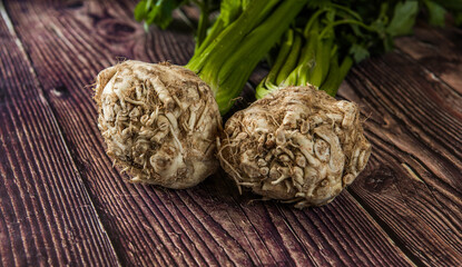 Tuber of celery with leaves, green bio vegetables from village gardening, farm fresh produce, organic food on wood