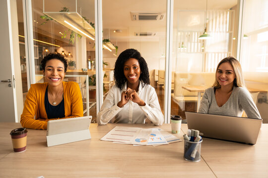 Portrait Of Female Business People Smiling And Looking At Camera In Meeting Room.