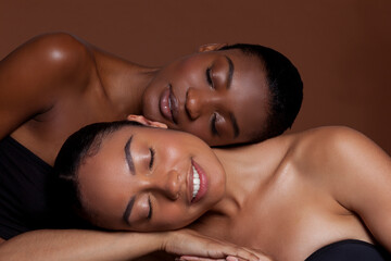 Smiling young women lying on top of each other