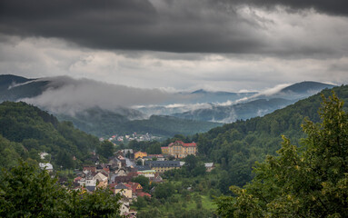 Fototapeta na wymiar rain and heavy black clouds over a small town in the valley / Štramberk, Czech Republic