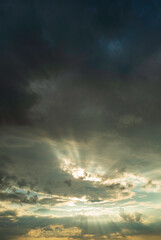 Fototapeta na wymiar Grey cloud sky with sun rays piercing the clouds. 