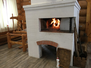 The fire in the old traditional russian village oven in a rustic style.   Baskets and the spinner...