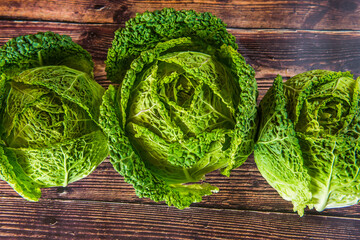 Fresh bio green garden cabbage on rustic wooden background from farm village gardening.