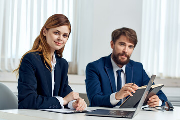 Fototapeta premium man and woman managers talking at the table in front of laptop office technology