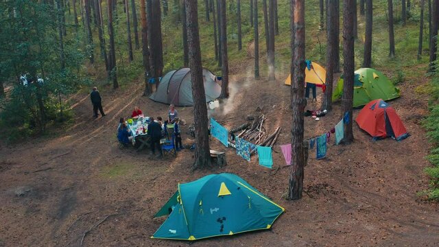 Family camping aerial. Aerial view of the extended family enjoying camping in the dry forest with pine trees