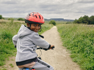 Portrait of boy riding bicycle in countryside