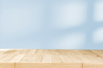 Wooden pedestal table with shadow on the earth-colored wall 