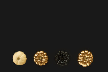 Golden, black and white pumpkin on a black background. Minimal Halloween concept. Flat lay, top view, copy space.