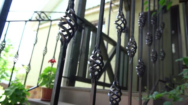Wrought iron stair railings. Volumetric fragment. Fencing in the house. Decorative element. Ironwork. Private house. Slow motion. Close-up.