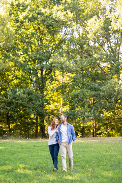 Smiling young couple having fun while walking in park