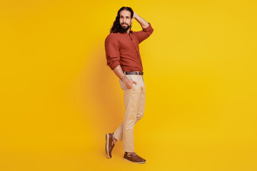 Fototapeta na wymiar Portrait of charming macho handsome guy hand pocket posing on yellow background