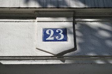 Close Up of Old Blue Plaque with Number 23 in White above Stone Entrance 