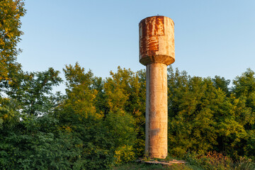 Old water tower in the countryside. Rusty construction.