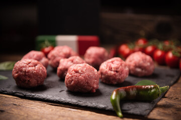  Raw meatballs on  dark basalt plate