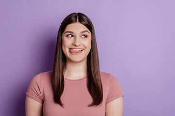 Fototapeta premium Close up portrait of young attractive woman licking her teeth yummy look empty space isolated on violet color background