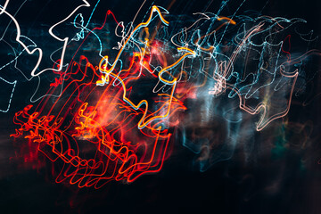 Bright lights blurred at night, abstract defocus background. Night city in motion, red lights, traffic