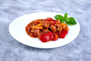 Hungarian goulash, pork stew on grunge background.