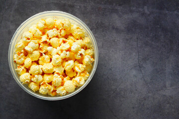  popcorn in a bowl on black tiles background 