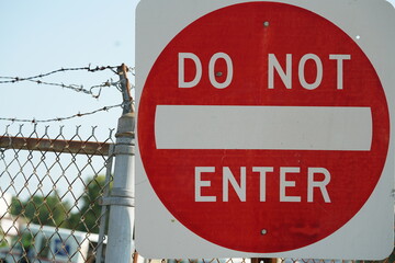 Barbed wire fence with warning sign
