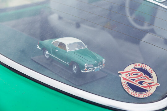 Toy Miniature Machine volksvagen karmann ghia coupe in the car interior. Minsk, Belarus - July 10, 2021