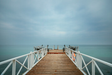 Pier with wooden plank flooring and hammocks to liven up the wait while enjoying the maritime horizon
