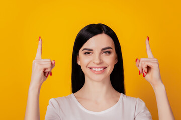 Portrait of positive confident girl promoter point index finger up adverts promo isolated over yellow color background