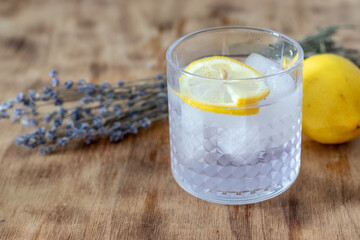 lavender lemonade with ice in a low glass glass stands on a table