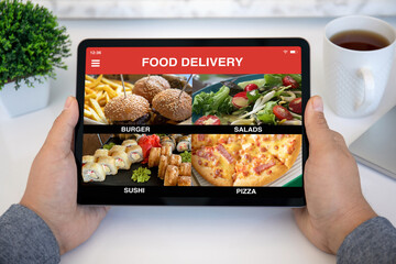 male hands holding computer tablet with with app food delivery