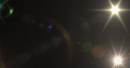 Spot of light and lens flare against black background