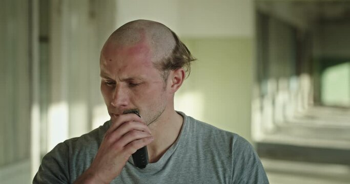 Unhappy bald man shaving mustache