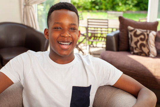 Smiling teenage boy sitting in armchair