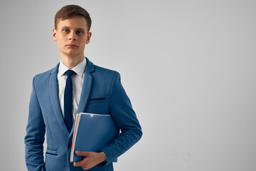 man in a suit with a blue folder in his hands work office official
