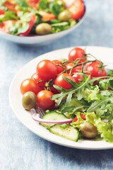 Healthy salad with green olives, cherry tomatoes and rocket. Close up.	