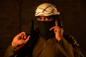 Terrorist or gangster with face cover blackmailing or asking for ransom over mobile phone call and...
