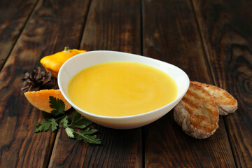 Concept of tasty food with pumpkin soup on wooden table