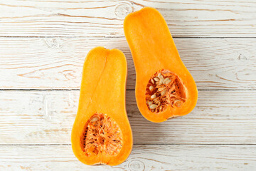 Halves of pumpkin on white wooden background