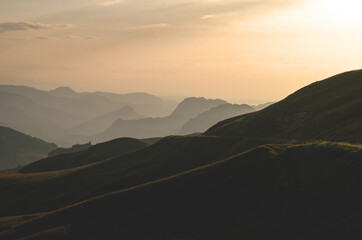 Beautiful panorama of green hills and mountains at sunset.