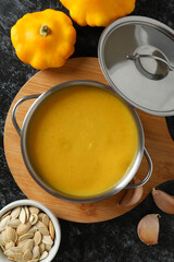 Concept of tasty food with pumpkin soup on black smokey table