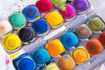 uncovered old palette of bright colored paints