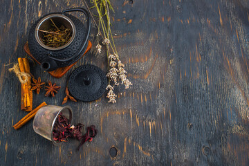 Green tea in a cast iron teapot and hibiscus tea on a wooden table.
